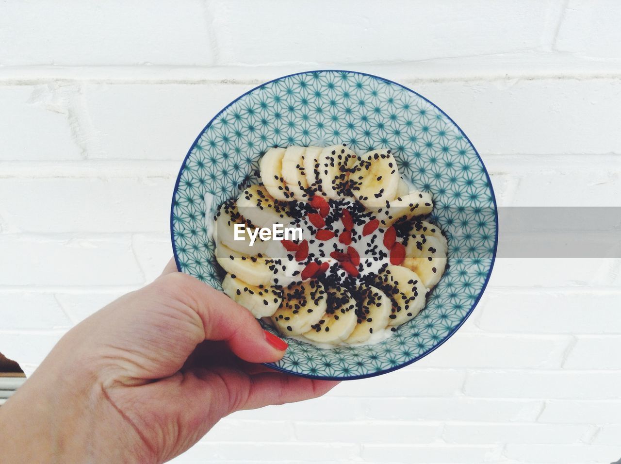 Cropped image of woman holding fruits in bowl