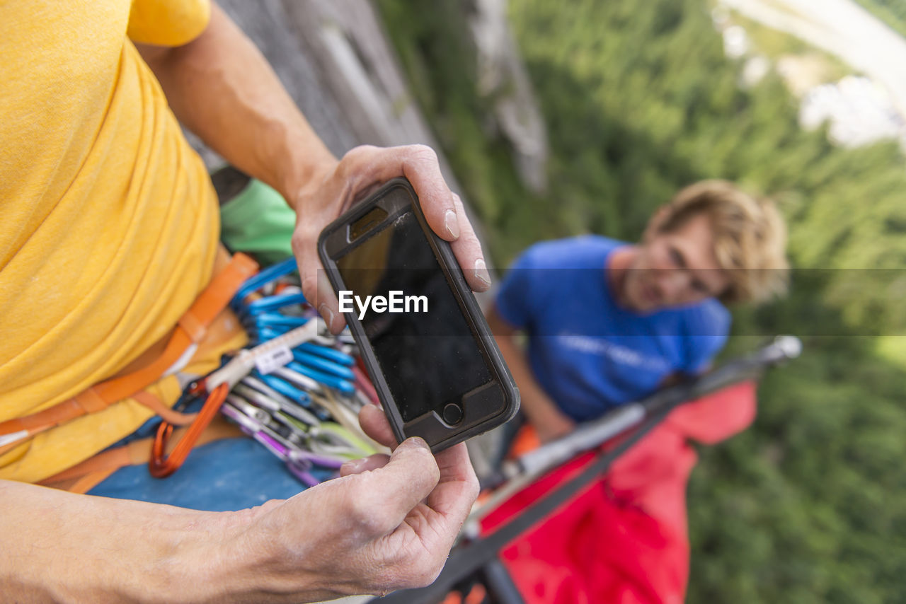 Climber looking at instruction on how to set up portaledge smartphone