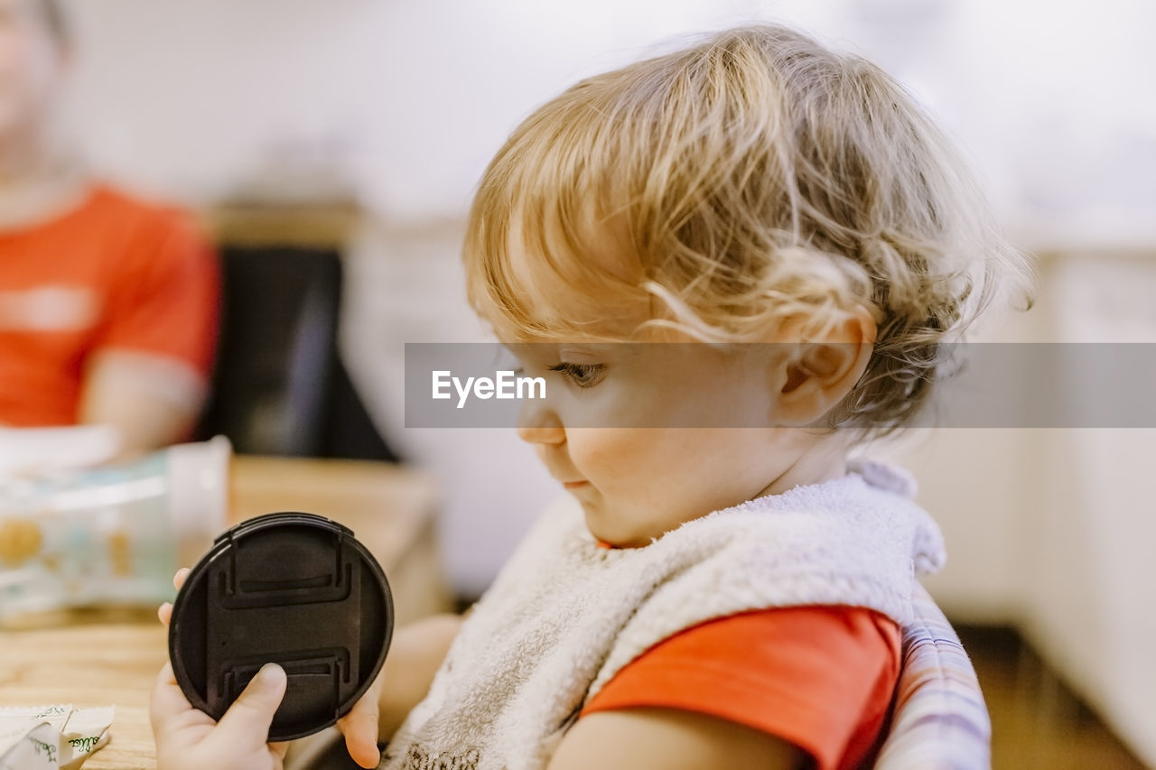 Close-up of girl holding lid at table