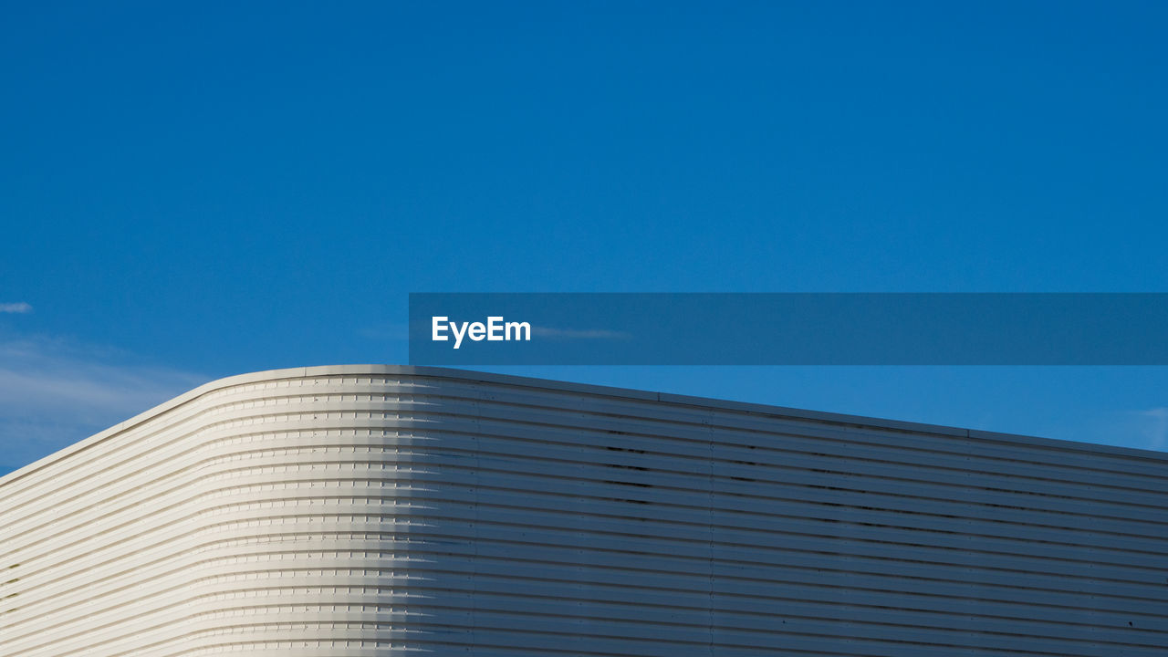 Low angle view of modern building against clear blue sky