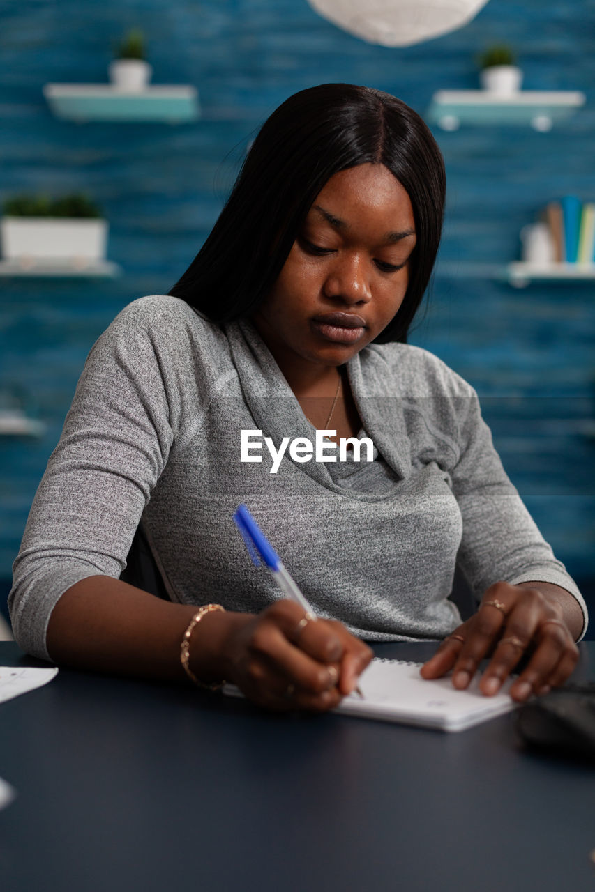 portrait of young woman writing in book