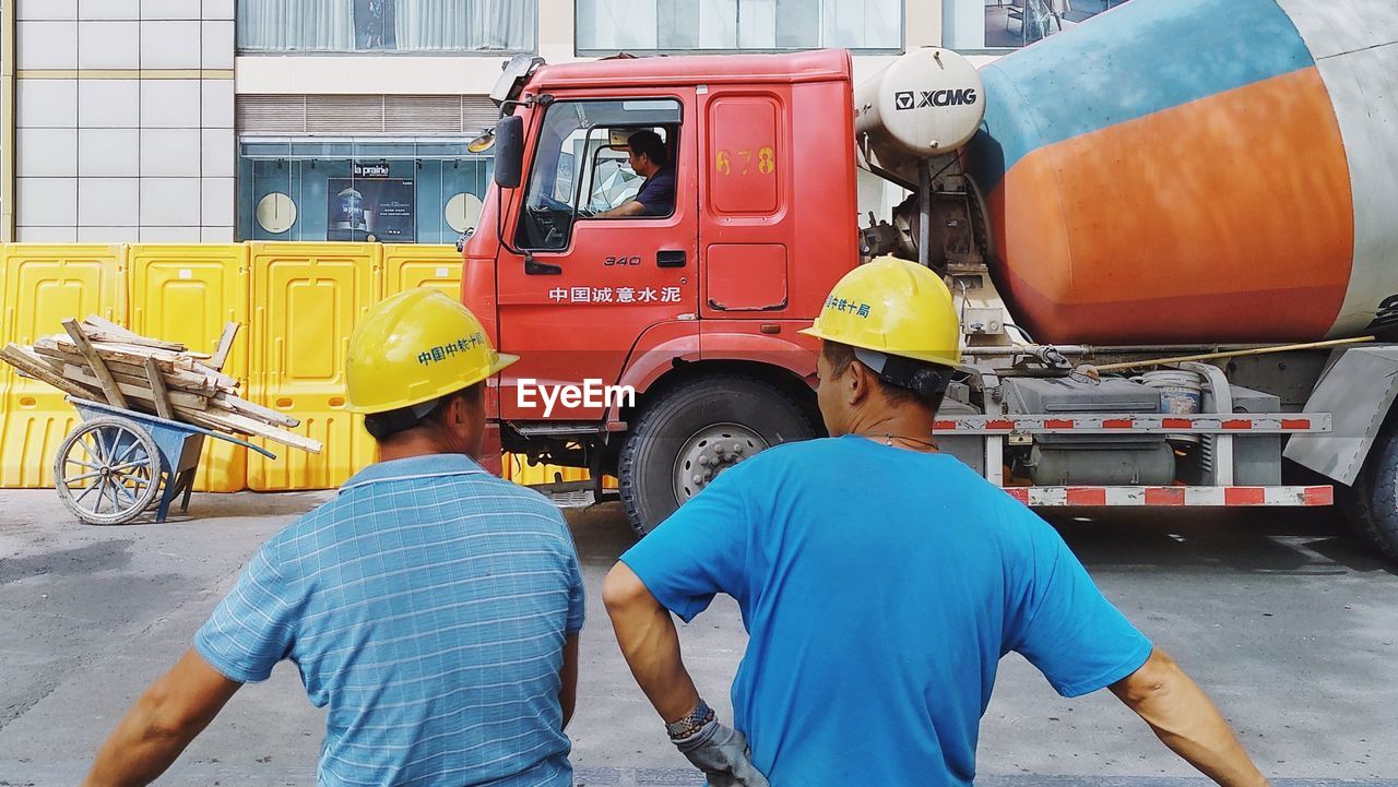 REAR VIEW OF MEN WORKING IN BUS