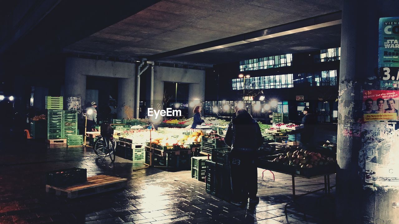 People at illuminated market stall