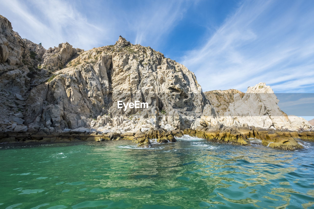 Rock formations in sea against sky