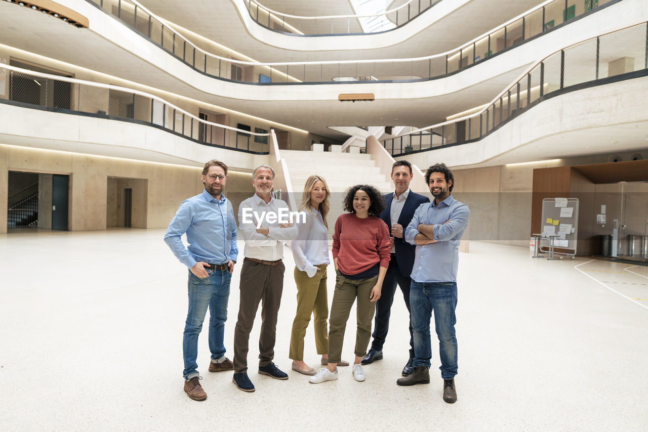 Smiling multiracial business colleagues standing in lobby