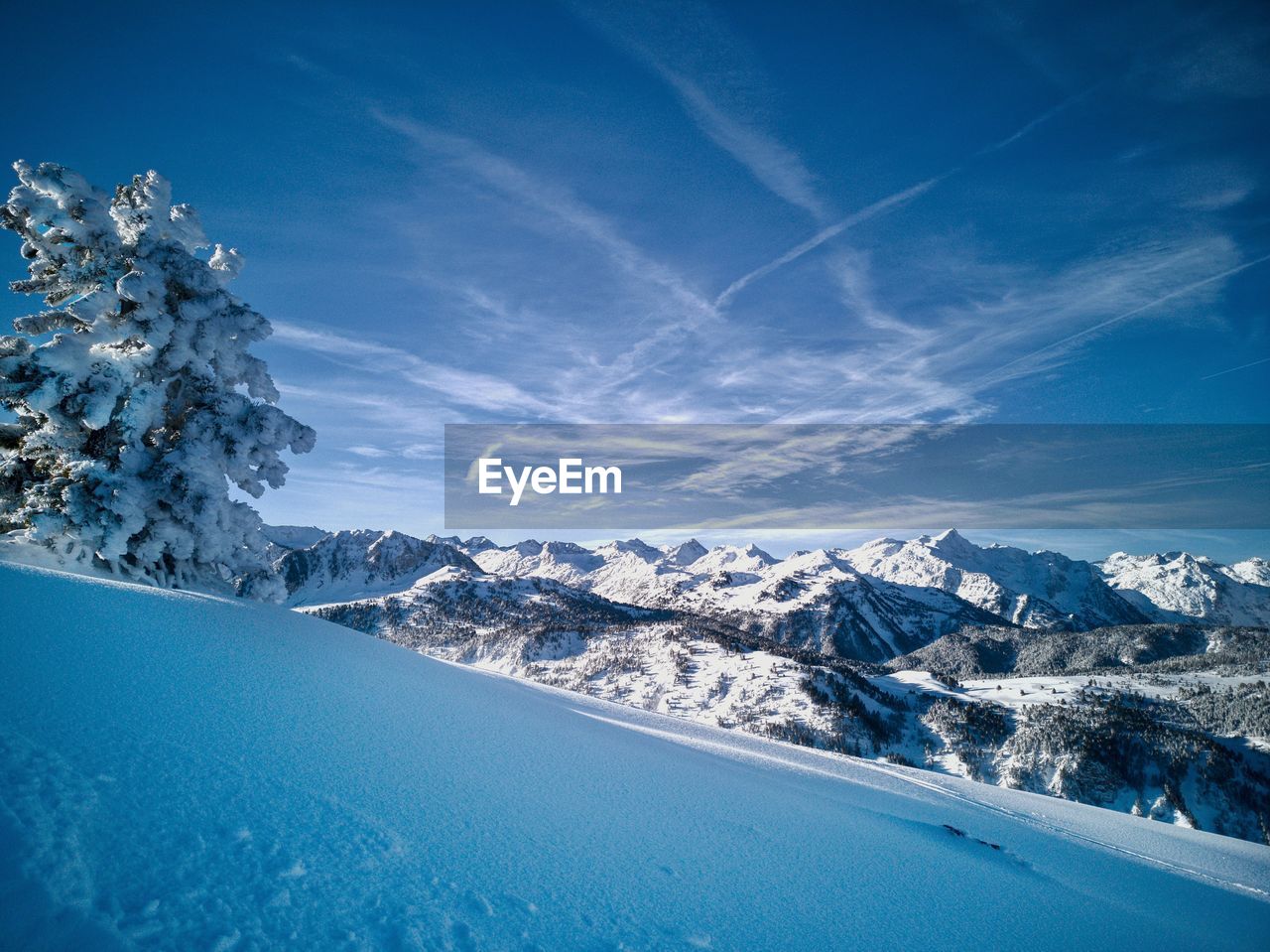 Aerial view of snowcapped mountains against blue sky