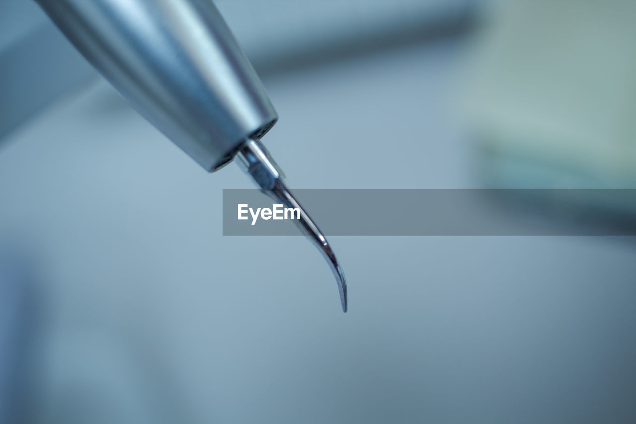 CLOSE-UP OF WATER DROP FROM FAUCET IN CONTAINER