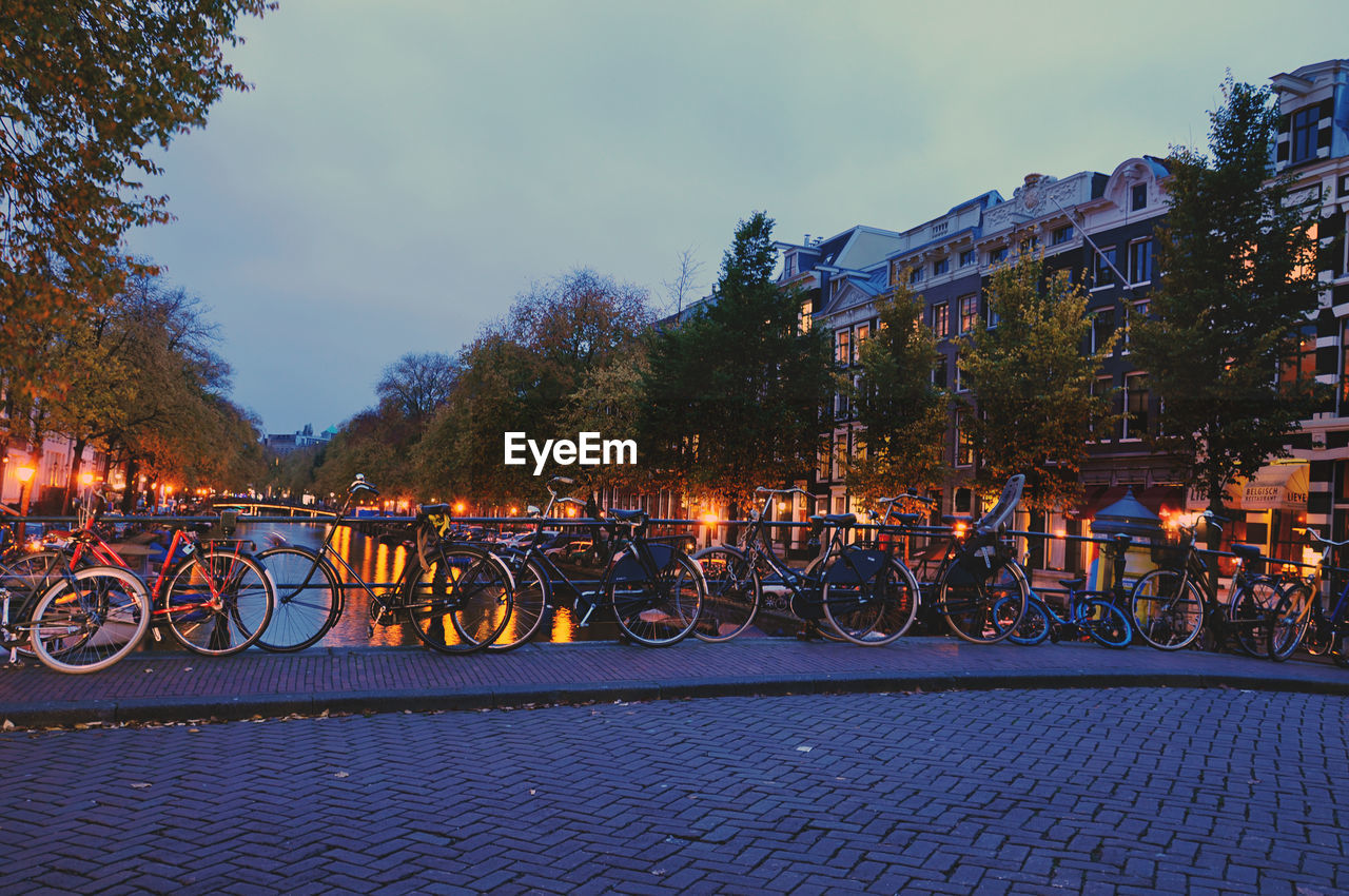 Bicycles parked on bridge over canal at dusk