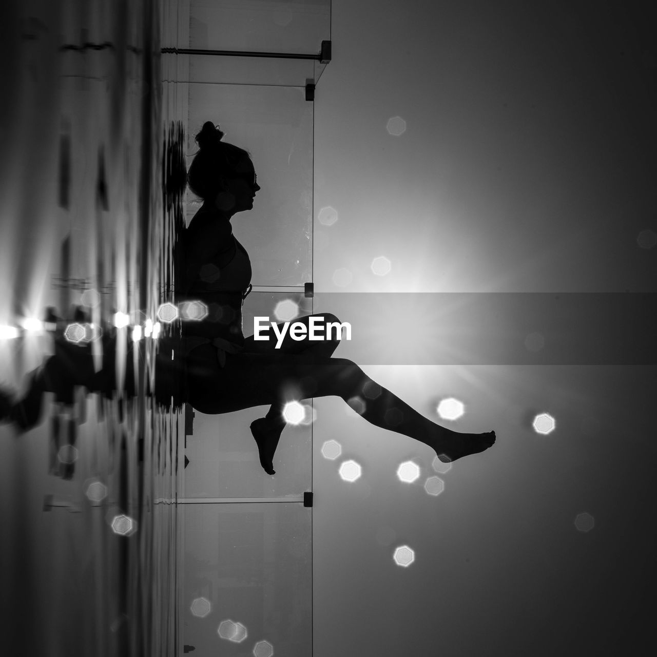 Surface level view of silhouette woman lying down against sky