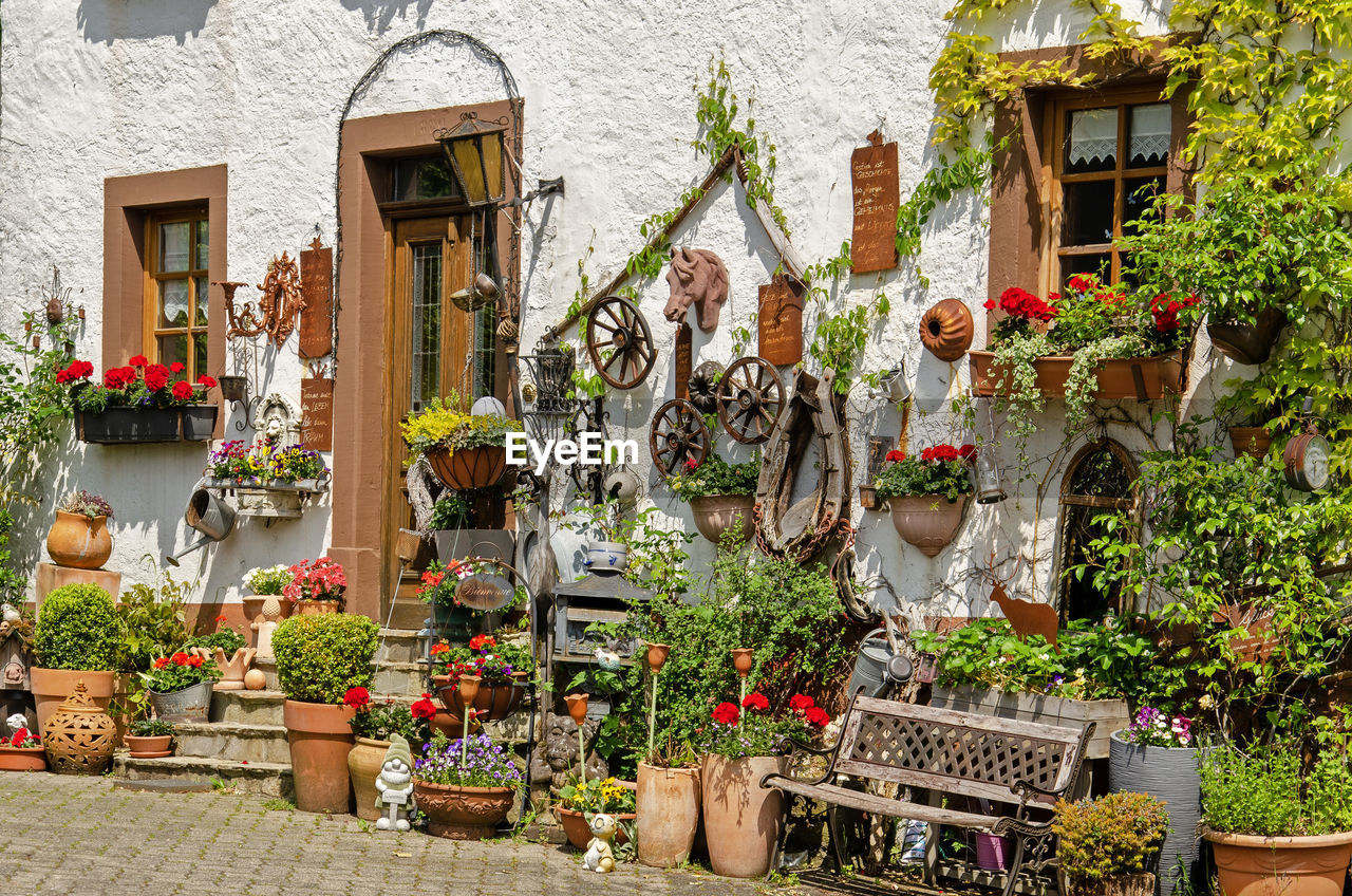 White plaster facade with pots, plants, wheels and other traditional objects