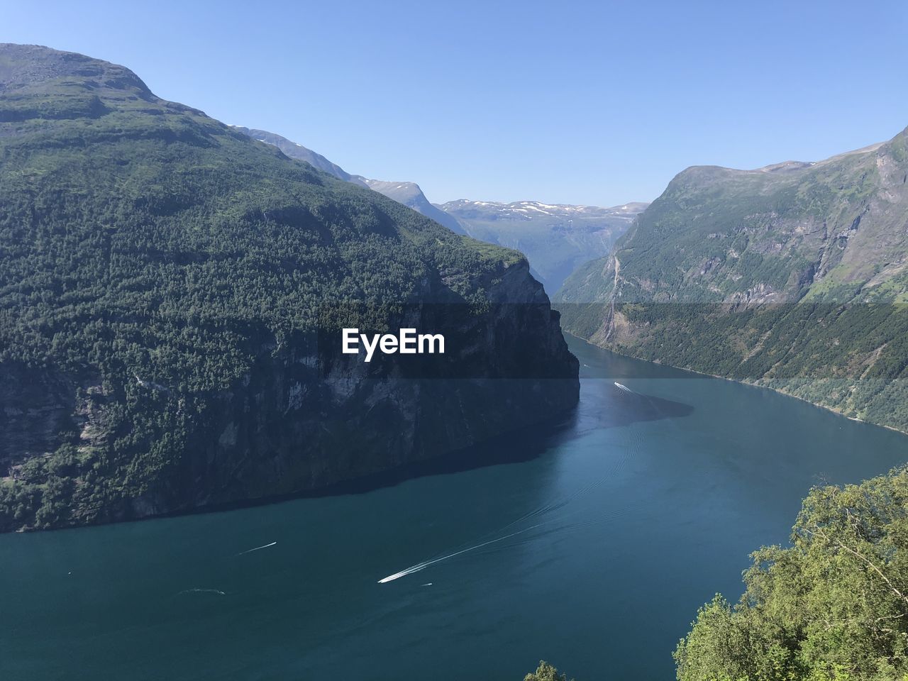 Scenic view of river amidst mountains against clear sky