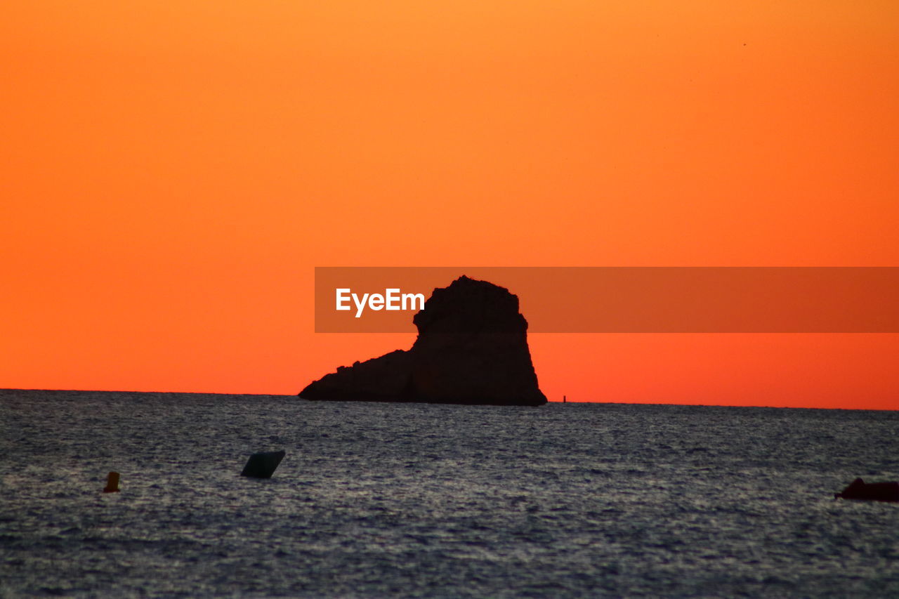 SCENIC VIEW OF ROCK FORMATION IN SEA AGAINST ROMANTIC SKY