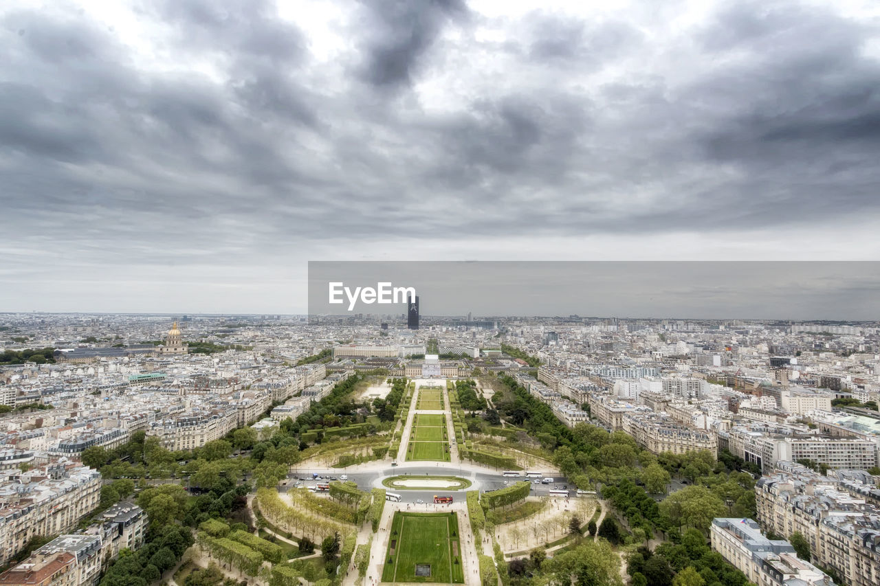 High angle view of buildings in city against cloudy sky