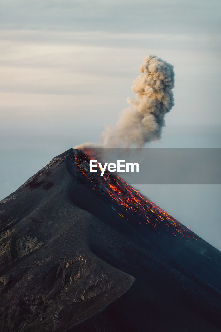 View of smoke emitting from volcanic mountain against sky