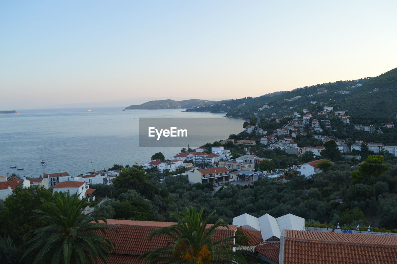 High angle view of town by sea against clear sky