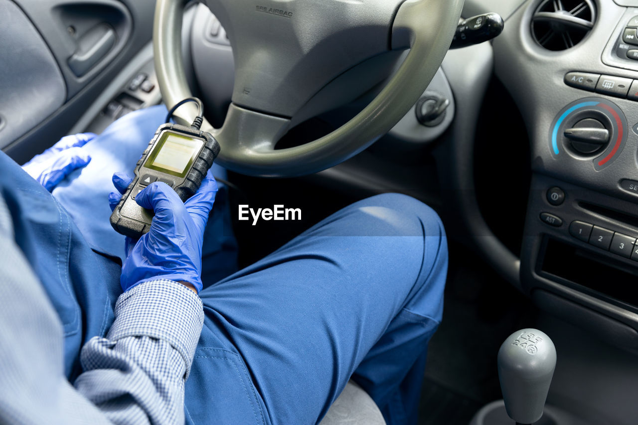 Auto mechanic using car diagnostic scan tool