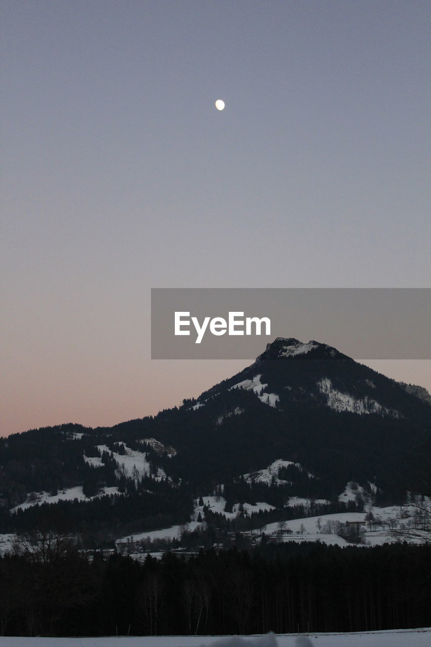 SCENIC VIEW OF SNOWCAPPED MOUNTAIN AGAINST SKY AT DUSK