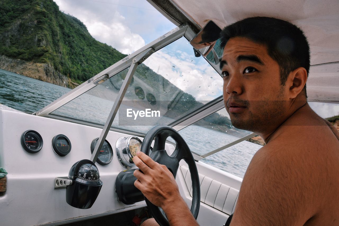 Young man driving boat