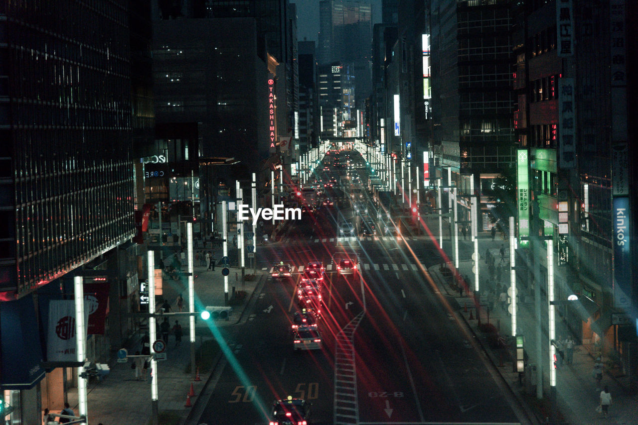 Traffic on city street by buildings at night