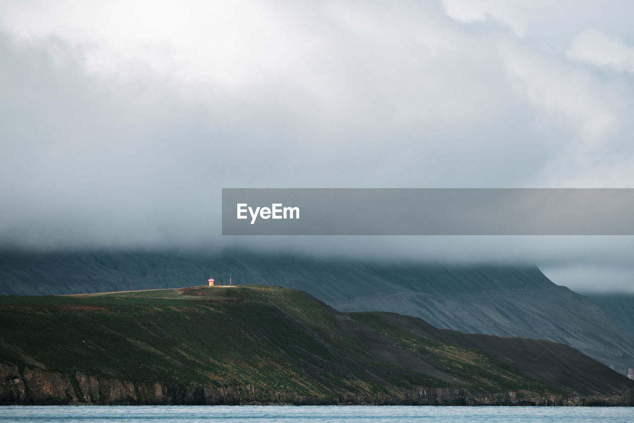 Scenic view of sea and mountains against sky