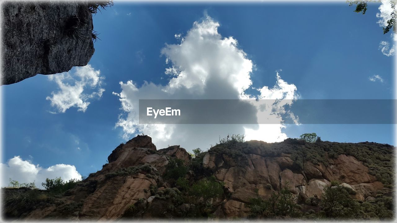 LOW ANGLE VIEW OF ROCKS ON MOUNTAIN AGAINST SKY