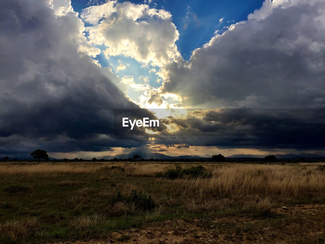 Countryside landscape against cloudy sky