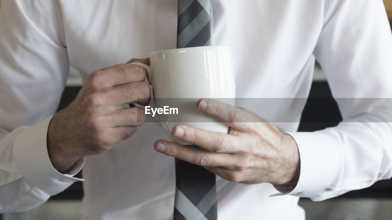 MIDSECTION OF MAN PREPARING COFFEE