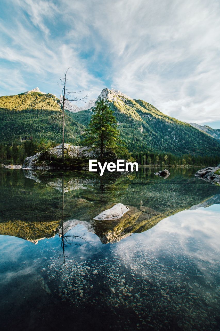 Scenic view of lake by mountains against sky