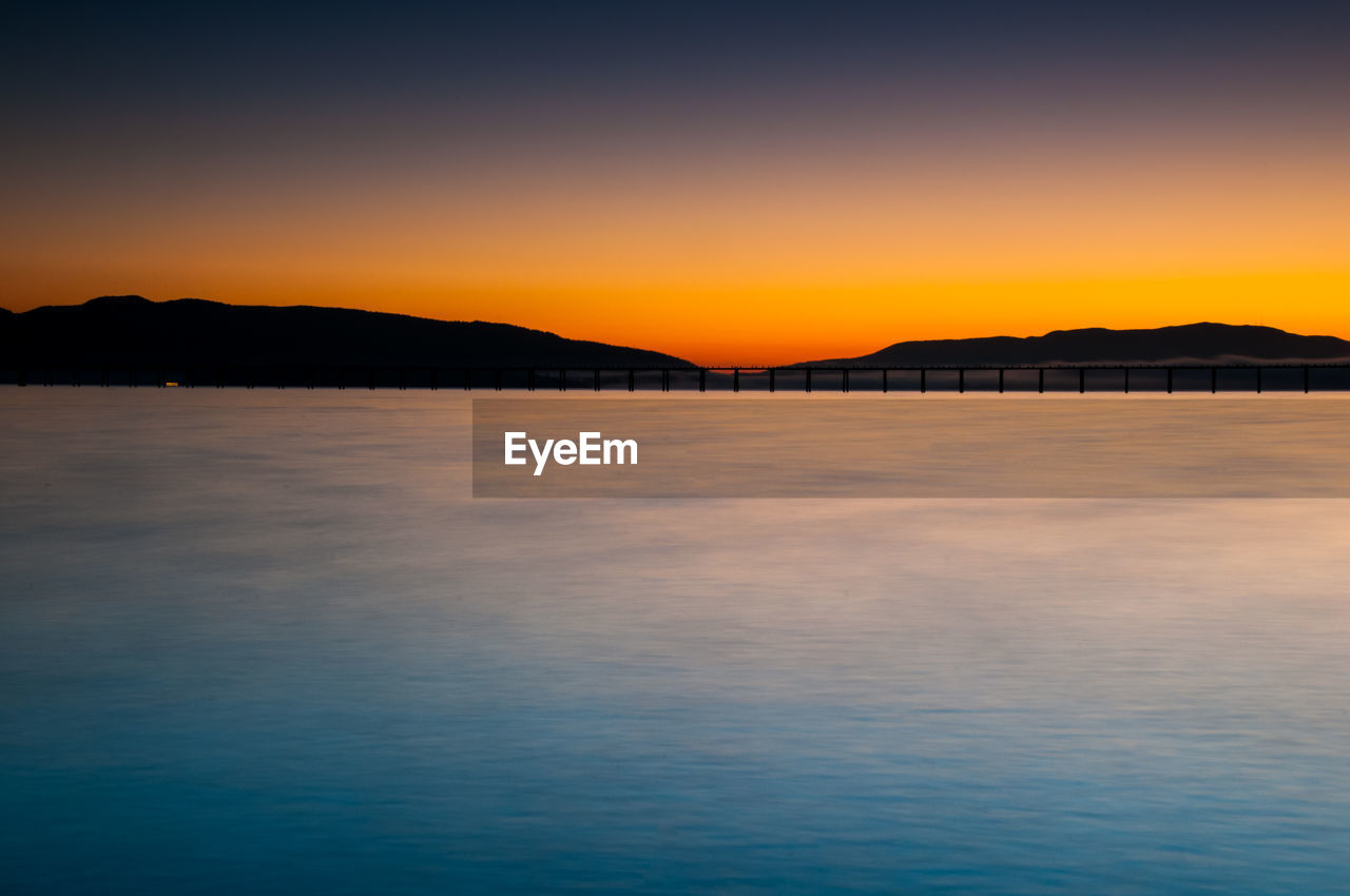 Scenic view of sea against clear sky at sunset