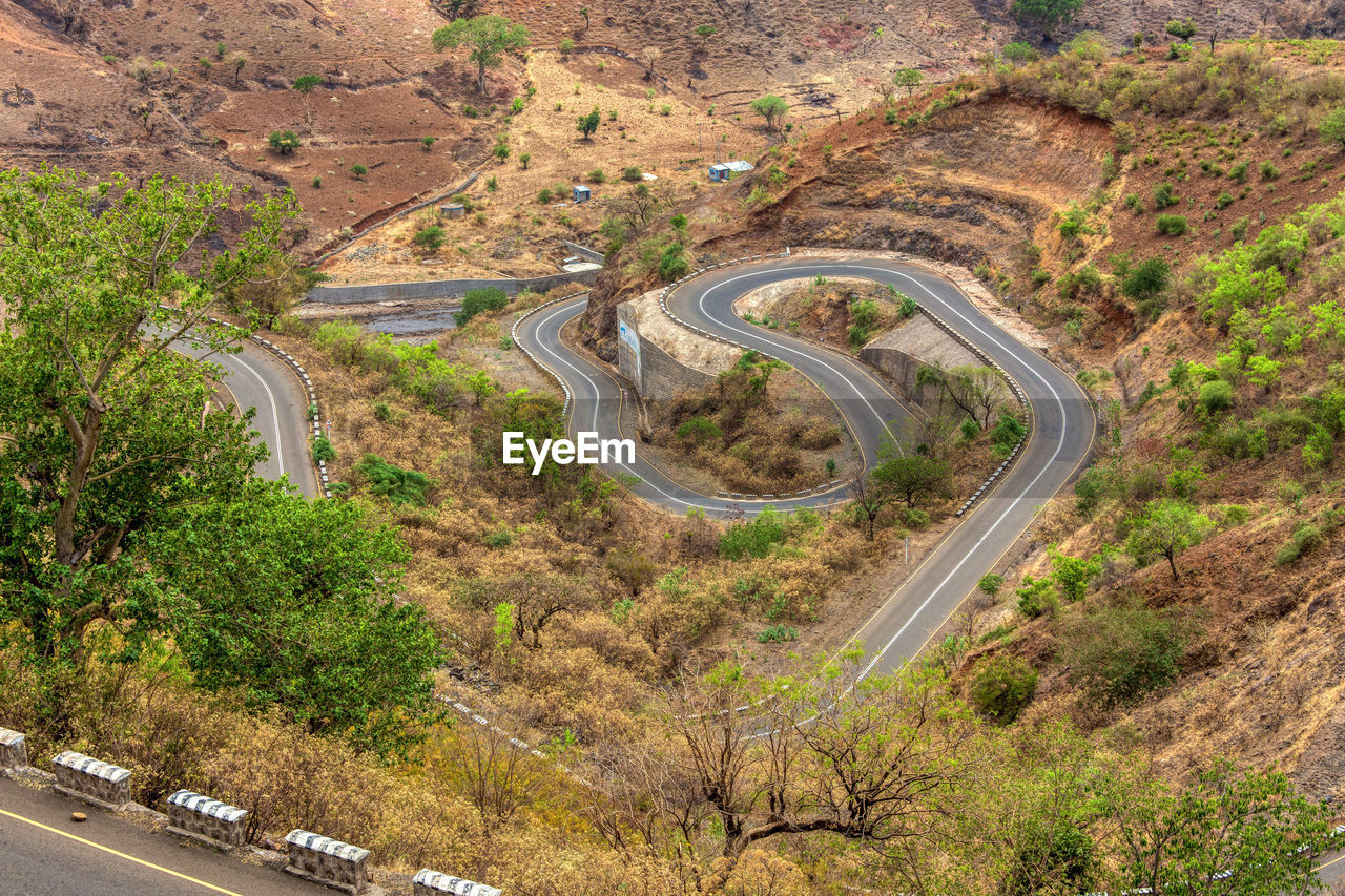 HIGH ANGLE VIEW OF ROAD AMIDST TREES ON MOUNTAIN