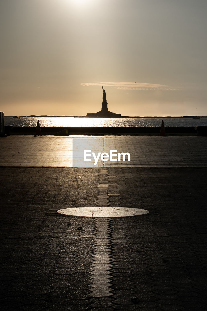 Scenic view of statue of liberty silhouette against the sky during sunset  from battery park