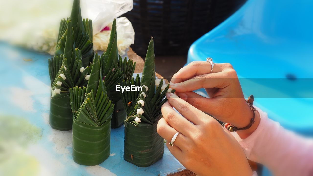 Cropped hands of woman making craftwork at table