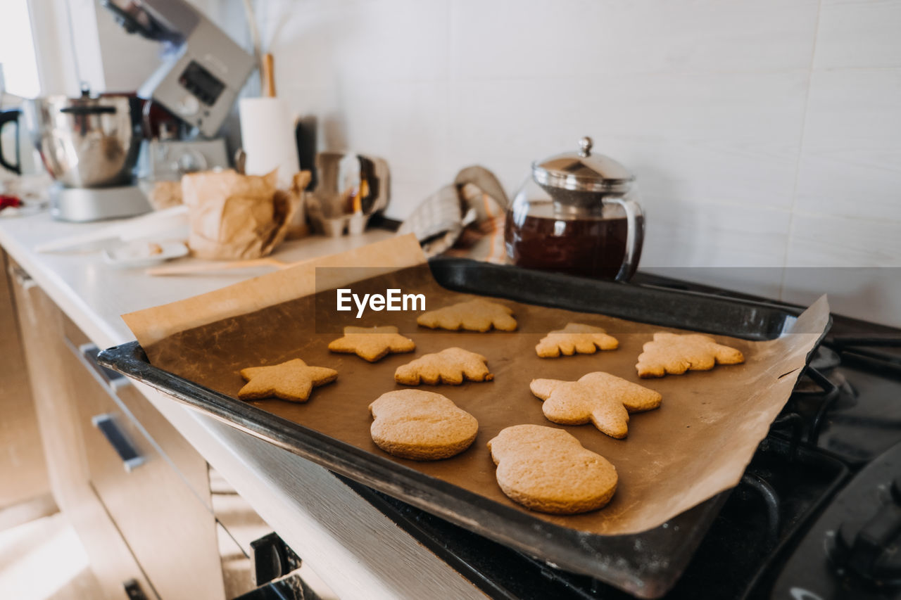 Christmas homemade gingerbread biscuit at baking pan on home kitchen. cooking at home, gingerbread