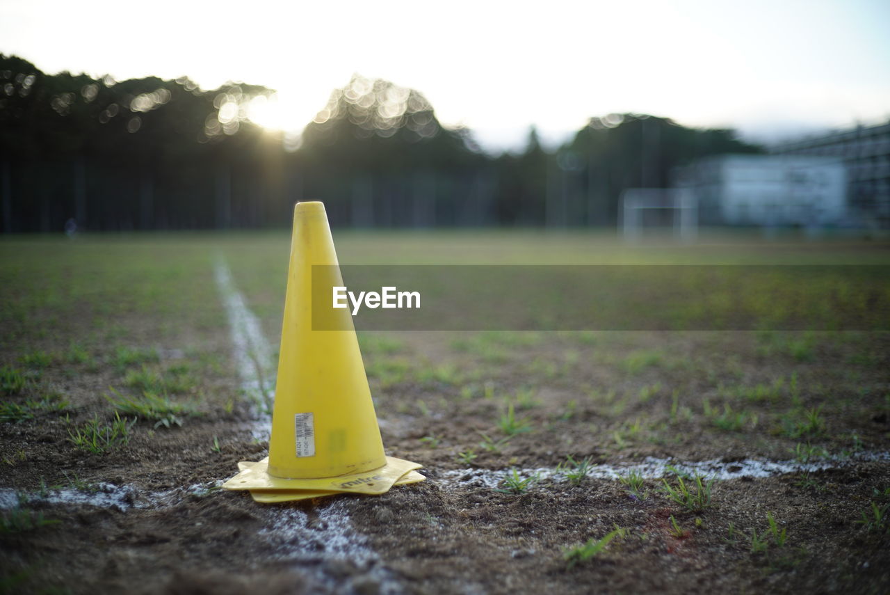 CLOSE-UP OF YELLOW PIPE ON FIELD