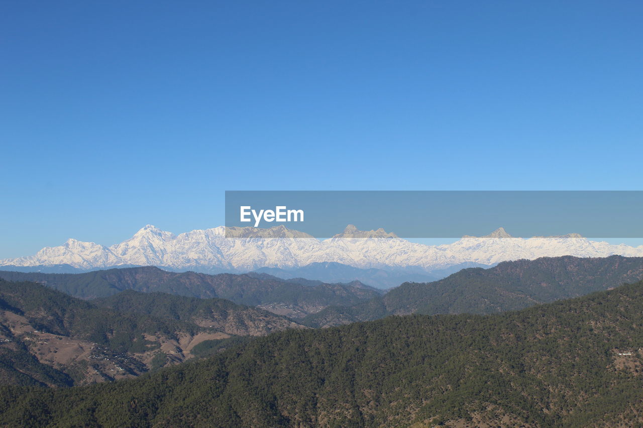 Scenic view of mountains against clear blue sky