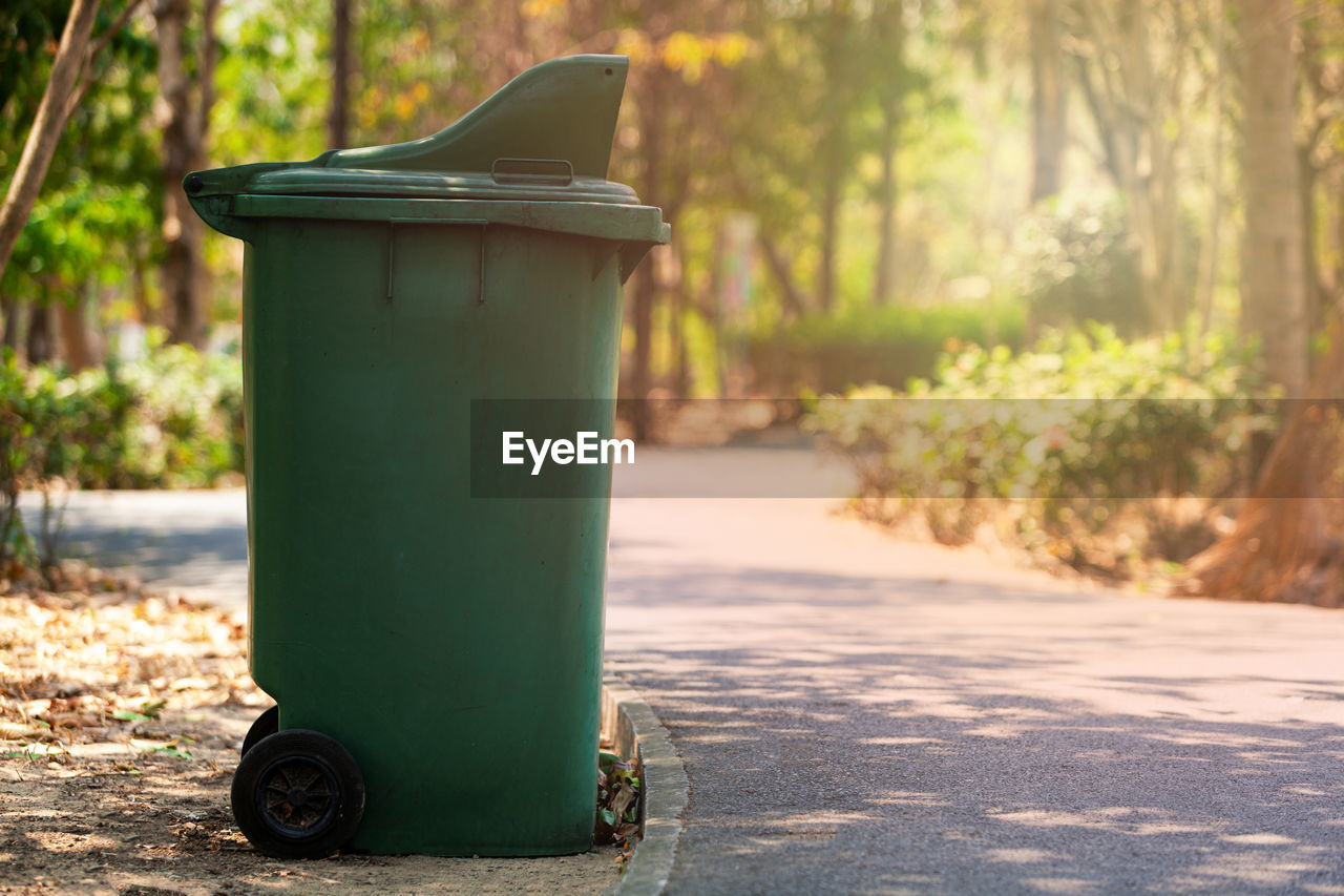 CLOSE-UP OF GARBAGE BIN BY STREET