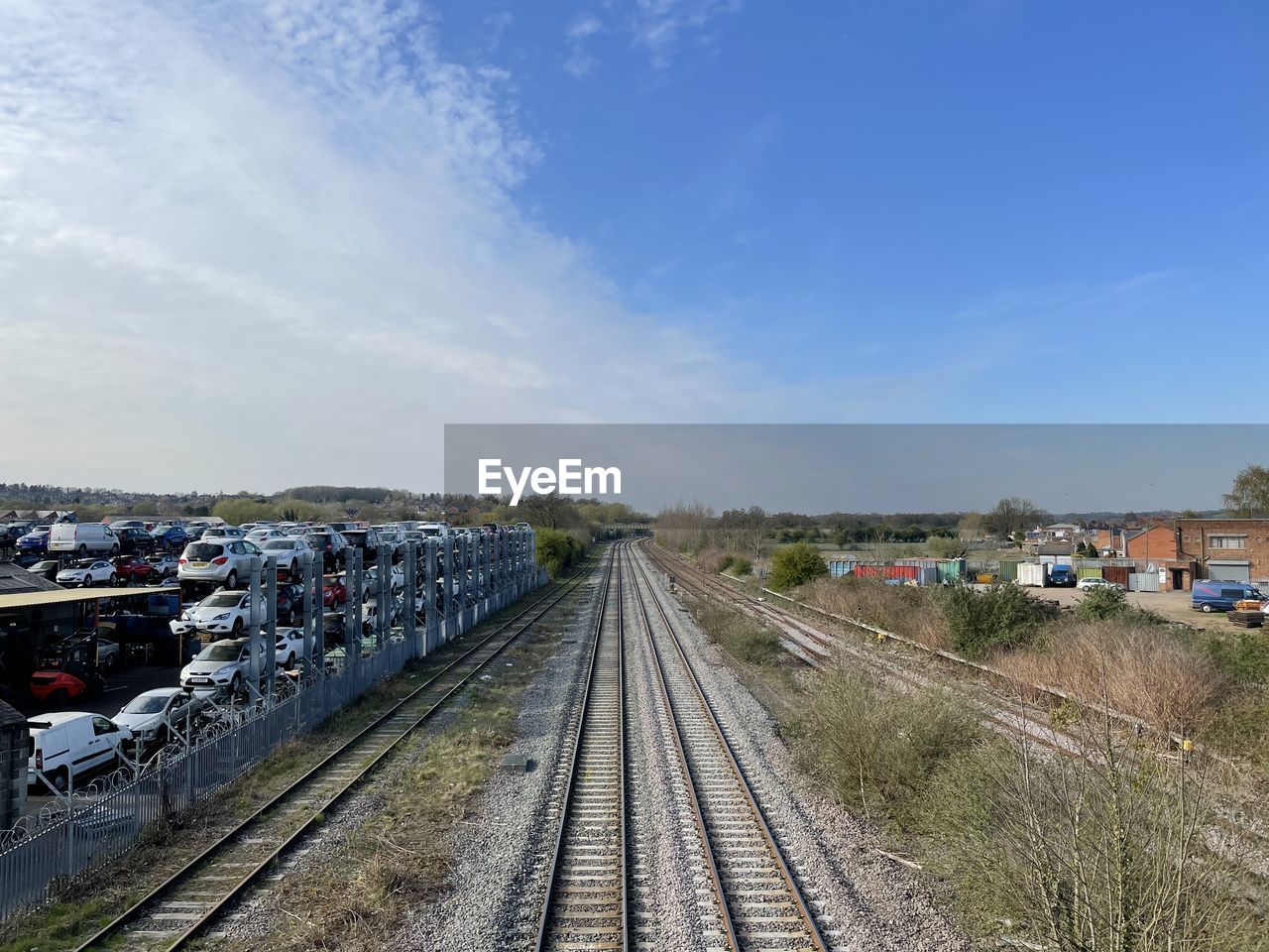 HIGH ANGLE VIEW OF TRAIN IN CITY AGAINST SKY