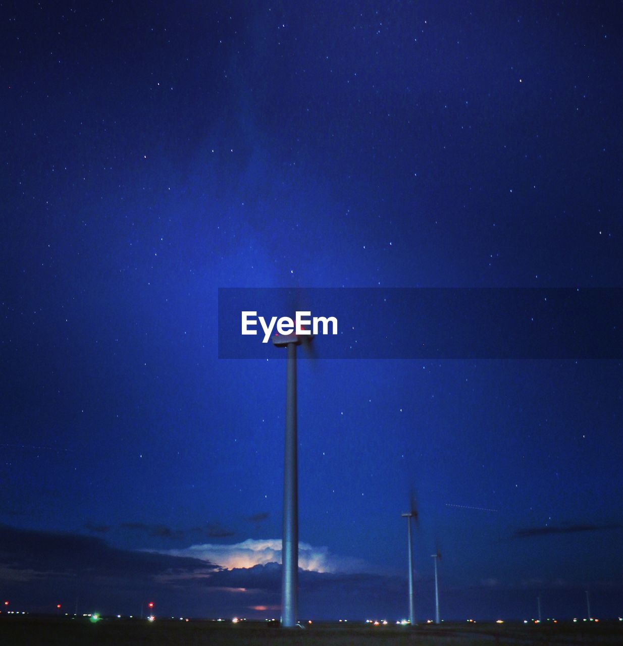 LOW ANGLE VIEW OF ILLUMINATED STAR FIELD AGAINST SKY