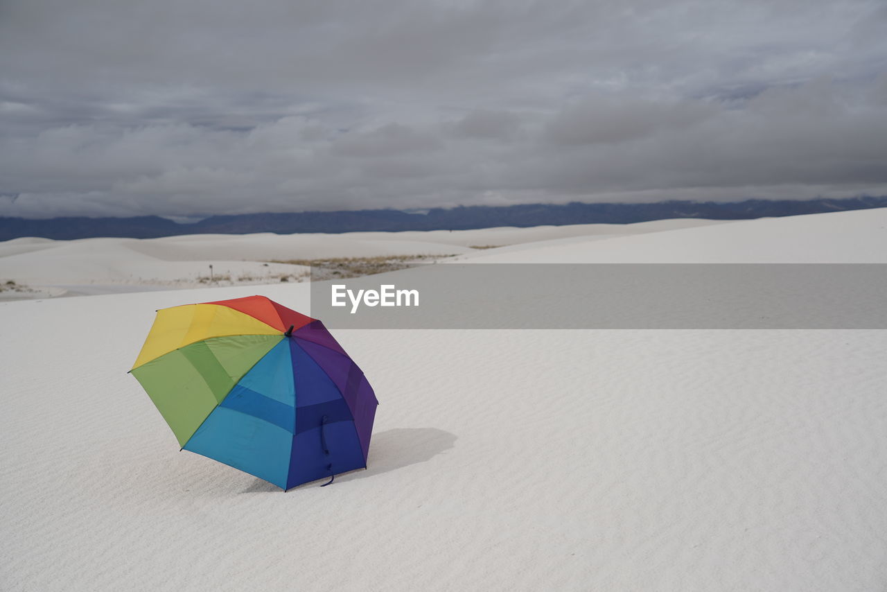 low angle view of umbrella on beach against sky