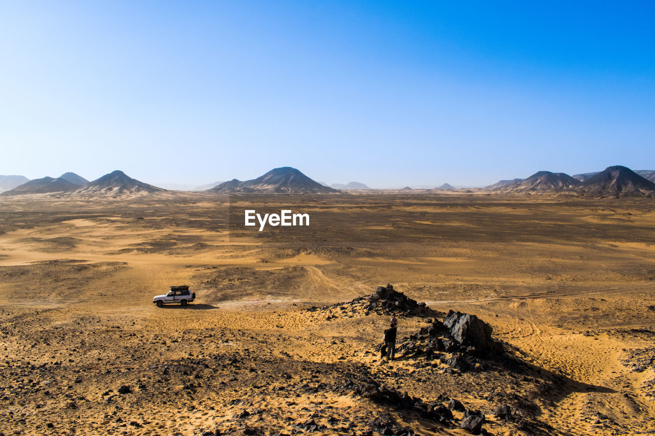 Scenic view of desert against clear sky. jeep truck in scene