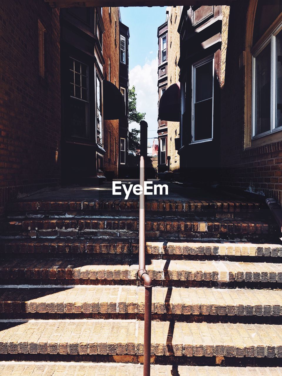 Steps amidst buildings in city on sunny day