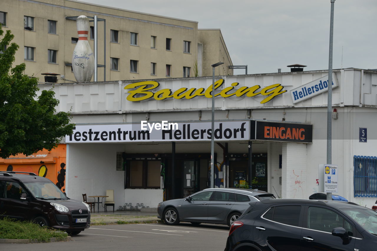 CARS ON ROAD AGAINST BUILDINGS