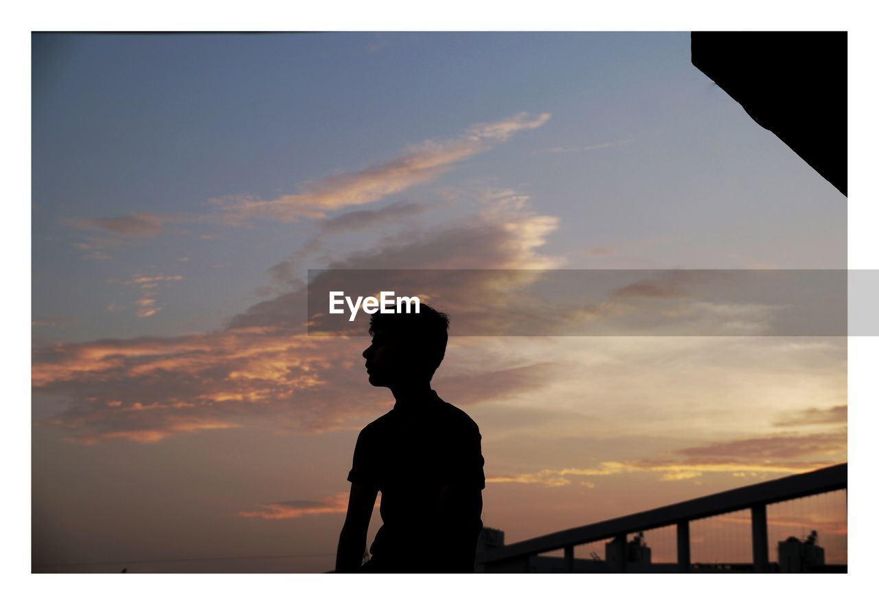 SILHOUETTE MAN STANDING AGAINST SKY