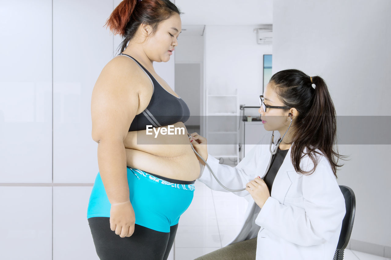 Doctor examining overweight patient at hospital