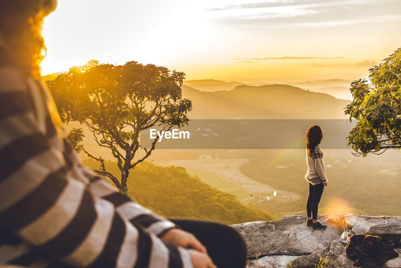 MAN LOOKING AT MOUNTAIN AGAINST SKY