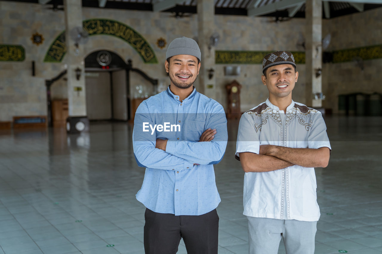 Portrait of smiling men standing at mosque
