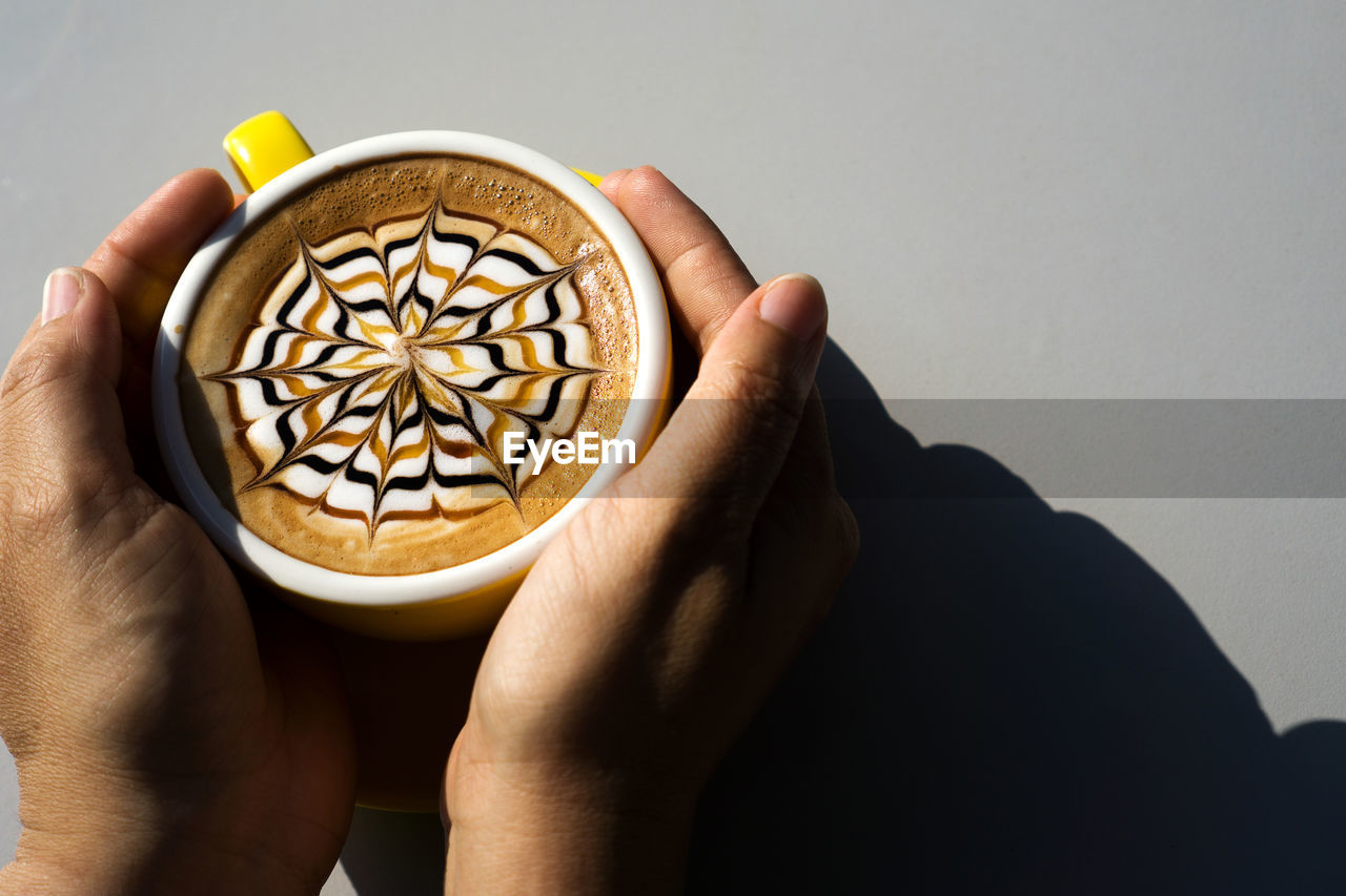 Close-up of hand holding coffee cup