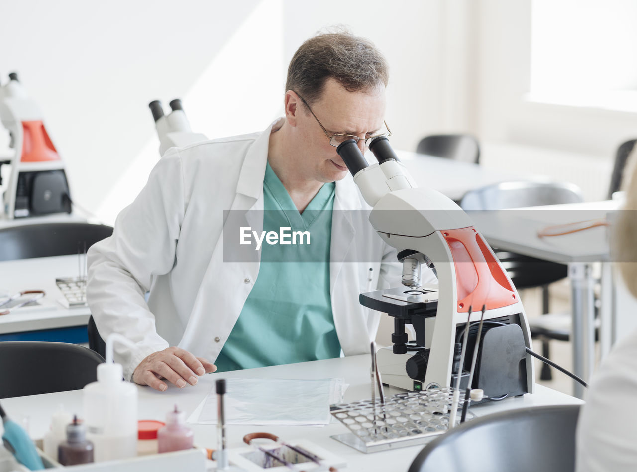 Senior researcher working with microscope in lab