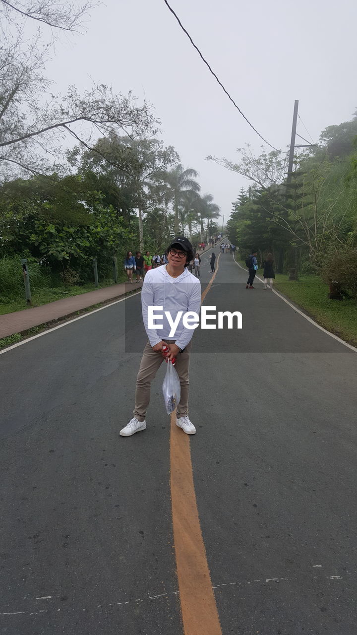 FULL LENGTH OF MAN WALKING ON ROAD