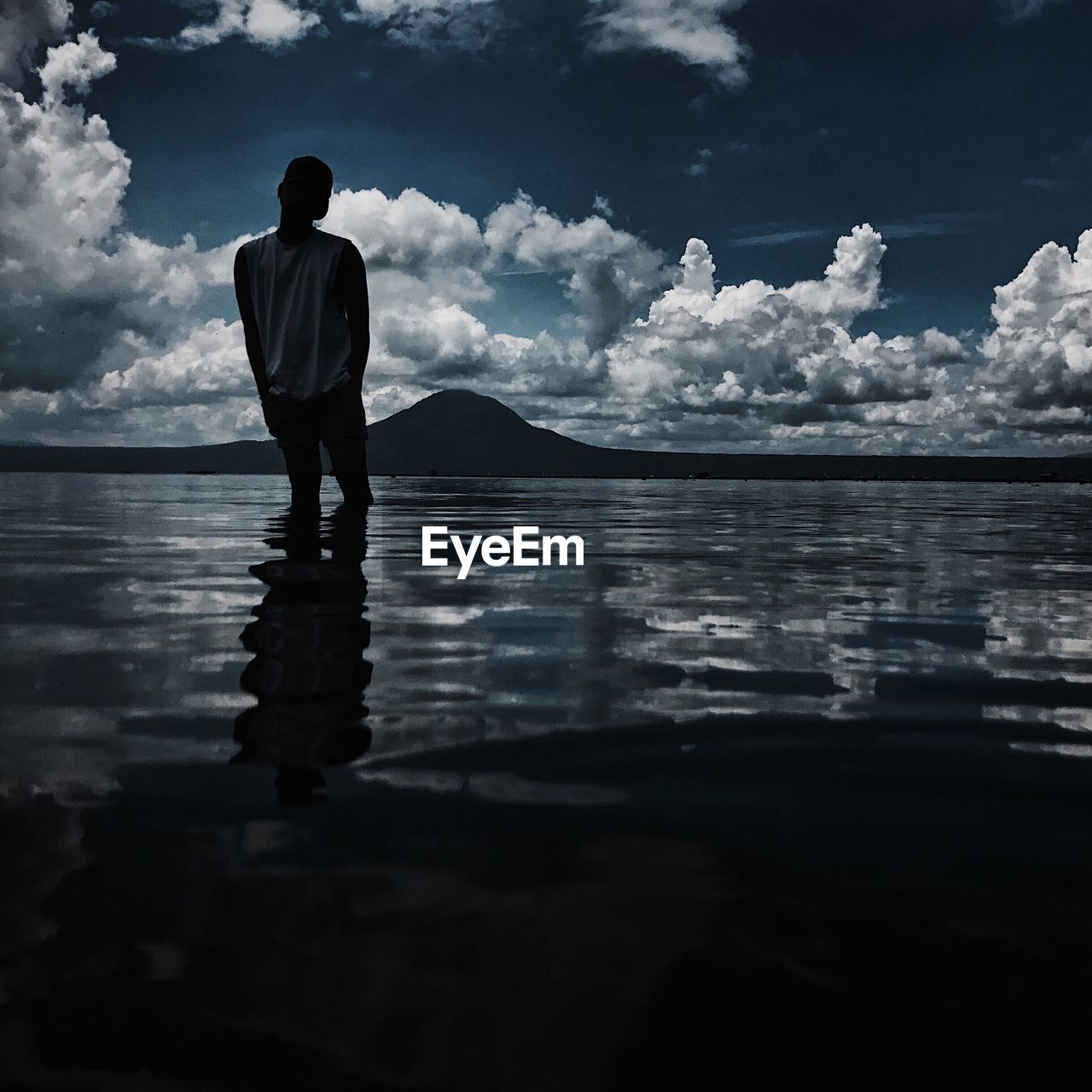 Man standing in sea against sky